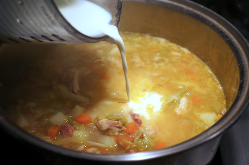 adding milk to soup